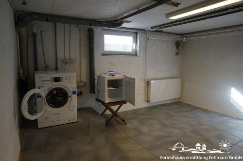 a laundry room with a washing machine and a microwave at 14 Ferienwohnung Inselparadies in Petersdorf auf Fehmarn