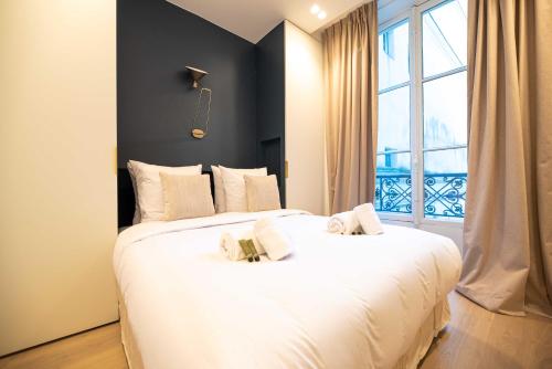 - 2 lits blancs dans une chambre avec fenêtre dans l'établissement Exceptional apt with AC-1BR-4P-Palais Garnier, à Paris