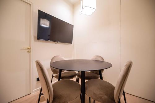 d'une table, de chaises et d'une télévision murale. dans l'établissement Exceptional apt with AC-1BR-4P-Palais Garnier, à Paris