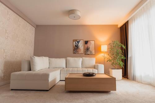 a living room with a white couch and a coffee table at Garden City Hotel Konjic in Konjic