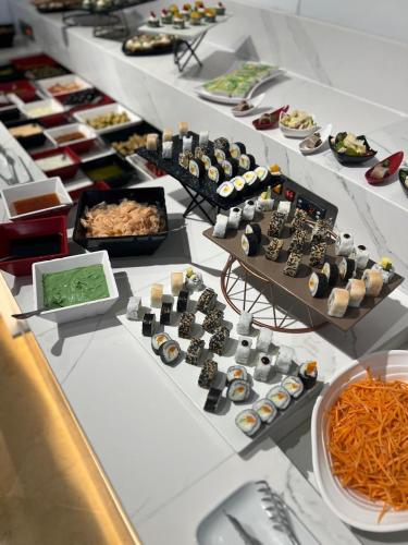 a buffet with sushi and other foods on display at One Resort Premium Hammamet in Hammamet Nord