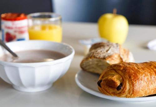 a table with a bowl of soup and a plate of bread at B&B HOTEL Clermont-Ferrand Gerzat in Gerzat