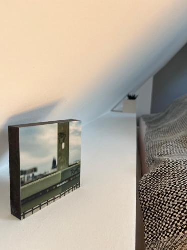 a television on a wall next to a bed at Helles Giebelzimmer im Altbau in Cologne