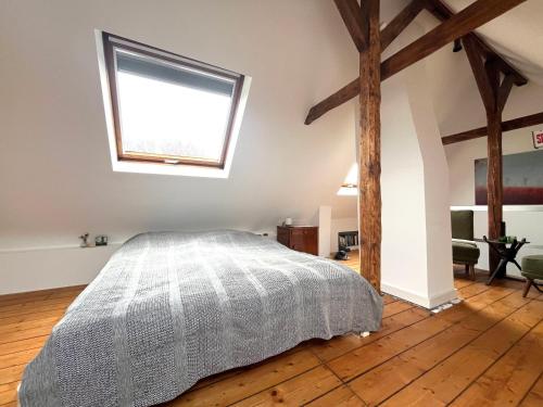 a bedroom with a bed and a window at Helles Giebelzimmer im Altbau in Cologne