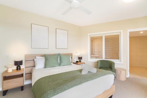 a bedroom with a large bed and a green chair at Quiet Apartment in Mantra Salt Beach by uHoliday - 2BR, 1BR and Hotel Room configurations available in Kingscliff