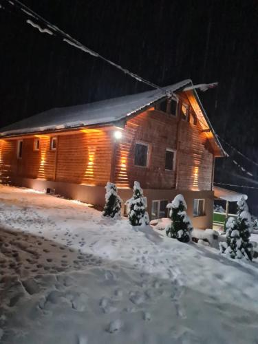 a log cabin in the snow at night at Šumska vila Gašić in Kopaonik