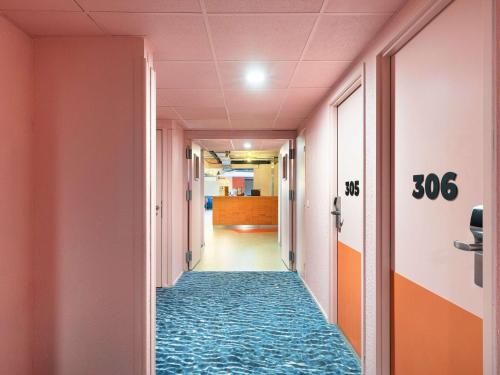 a corridor in an office building with a carpeted hallway at Greet Hotel Nice Aéroport Promenade des Anglais in Nice