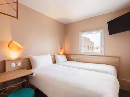 two beds in a small room with a window at Greet Hotel Nice Aéroport Promenade des Anglais in Nice