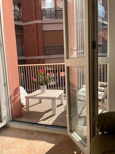 a balcony with a table with a vase of flowers at CASA TIO PIERO Centrale accogliente e confortevole in Asti