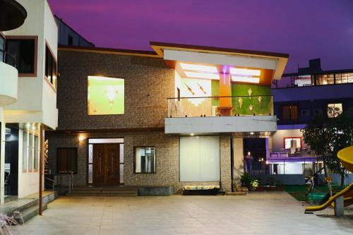 a brick building with a balcony and a building at Royal Retreat Lonavla - 7BHK Luxury Villa with Turf in Lonavala