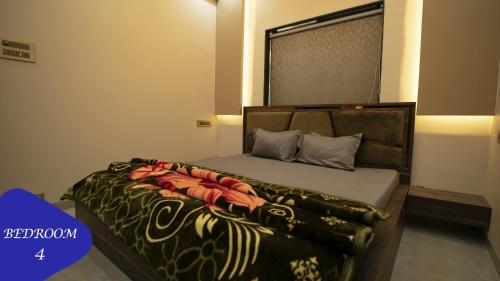 a bedroom with a large bed with a black and orange blanket at Royal Retreat Lonavla - 7BHK Luxury Villa with Turf in Lonavala