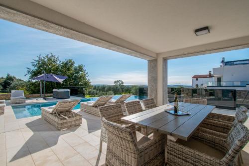 a patio with a table and chairs and a pool at Villa Bella near Rovinj and Pula in Bale