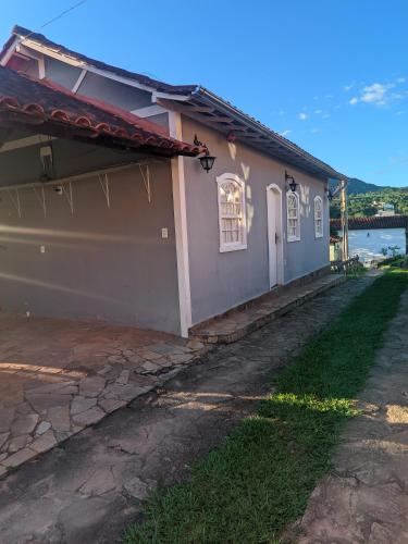 a pink house with a stone driveway next to a building at Casa encanto das Gerais in Tiradentes