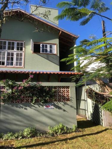 a green house with a window on the side of it at Casa brisa mar in Pontal do Paraná
