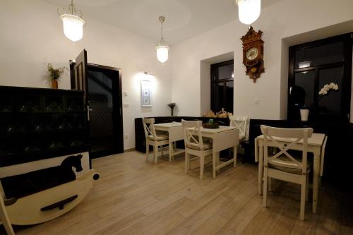 a dining room with tables and chairs and a clock at Vila Mila in Bled