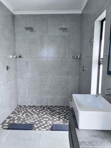 bagno con doccia, vasca e lavandino di Turaco Lodge - No Loadshedding a Marloth Park