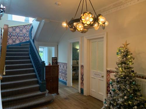 a christmas tree in a living room with a staircase at Bayswell Park Hotel in Dunbar