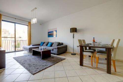 a living room with a couch and a table at Modern 2BR Sliema Apartment in Sliema