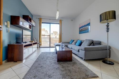 a living room with a couch and a tv at Modern 2BR Sliema Apartment in Sliema
