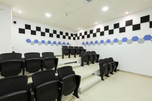 a conference room with black chairs and a white wall at Apartamentos Martalia Áticos Deluxe in Ronda