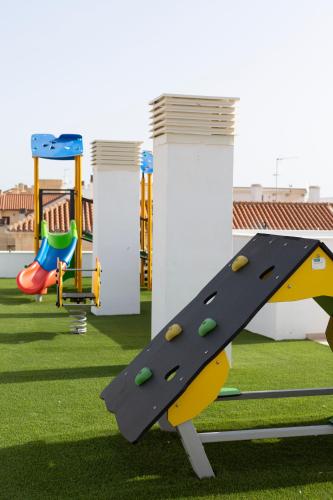 a playground with a slide on the grass at Apartamentos Martalia Áticos Deluxe in Ronda