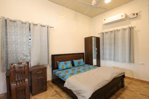 a bedroom with a bed with blue pillows at Aditya Cottage in Rishīkesh