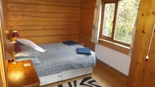 a bedroom with a bed in a log cabin at Hand built log cabin at Avonvale Holiday Lodges in Evesham