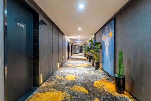 a corridor of an office with potted plants at HeSu Hidden Art Hotel & Suites - Near Bell Tower & Ideal Location-Spacious rooms featuring King or Double Queen beds -Exclusive Two&Three-Bedroom Suites with Expansive Living Rooms for Group Gathering-Kitty Cuddles & Coffee Gift -Seamless Journey Planning in Xi'an