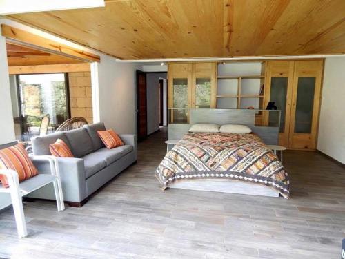a bedroom with a bed and a couch at River Home in Valle de Bravo