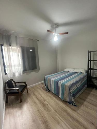 a bedroom with a bed and a ceiling fan at Apto pé na areia in Mongaguá