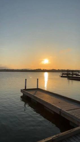 a dock on a lake with the sunset in the background at Cozy private backyard garden studio in Pickering