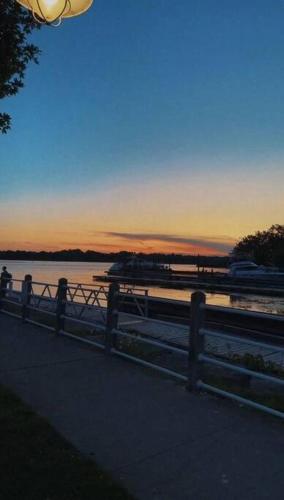 a sunset over a body of water with a fence at Cozy private backyard garden studio in Pickering