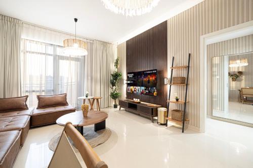 a living room with a couch and a tv at 1BR Apartment - Luxury, Spacious and balcony at Al Zahia in Sharjah