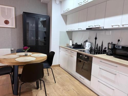 a kitchen with a wooden table and a table and chairs at PB EasyStay in Szczytno
