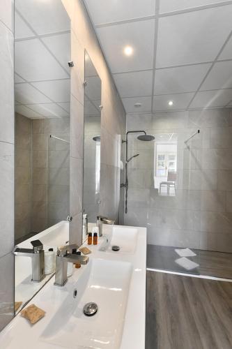 a white bathroom with a sink and a shower at Les Portes du Cantal in Massiac