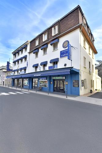 a large white building on a city street at Les Portes du Cantal in Massiac