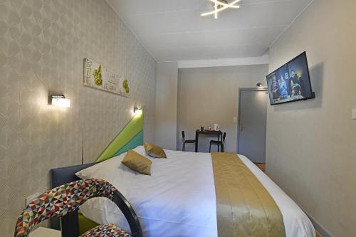 a bedroom with a white bed with a ceiling at Les Portes du Cantal in Massiac