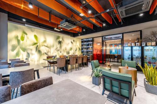a dining room with tables and chairs in a restaurant at HeSu Hidden Art Hotel & Suites - Near Bell Tower & Ideal Location-Spacious rooms featuring King or Double Queen beds -Exclusive Two&Three-Bedroom Suites with Expansive Living Rooms for Group Gathering-Kitty Cuddles & Coffee Gift -Seamless Journey Planning in Xi'an