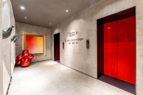 a hallway with a red door with writing on the wall at HeSu Hidden Art Hotel & Suites - Near Bell Tower & Ideal Location-Spacious rooms featuring King or Double Queen beds -Exclusive Two&Three-Bedroom Suites with Expansive Living Rooms for Group Gathering-Kitty Cuddles & Coffee Gift -Seamless Journey Planning in Xi'an