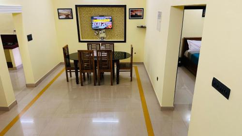 a dining room with a table and chairs and a bed at Golden pearl private villa with pool in Vythiri