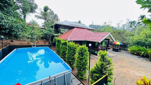 a house with a swimming pool next to a building at Golden pearl private villa with pool in Vythiri