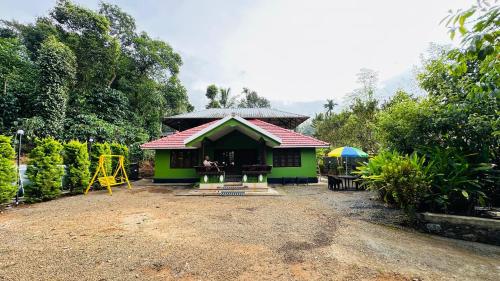 a small house with a red roof and a playground at Golden pearl private villa with pool in Vythiri