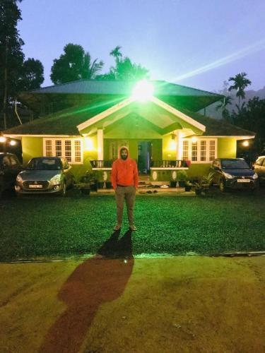 a man standing in front of a house at Golden pearl private villa with pool in Vythiri