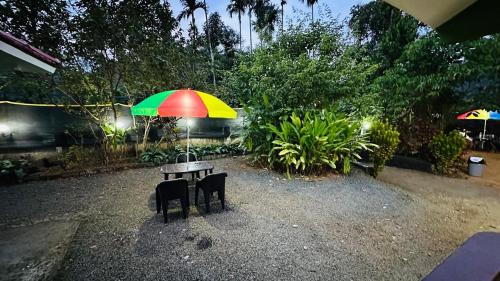 a table with a colorful umbrella on top of it at Golden pearl private villa with pool in Vythiri