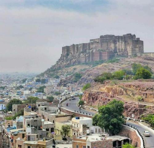 a view of a city with a mountain in the background at UGS guest house in Jodhpur