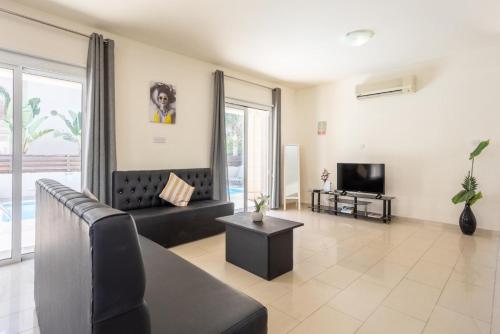 a living room with a couch and a tv at Villa Koula in Paralimni