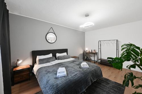 Un dormitorio con una cama y un reloj en la pared. en SANO - Bei Holger in Hagen - Ruhige Lage - Stylisch - Waschmaschine - Platz zum Arbeiten, en Hagen