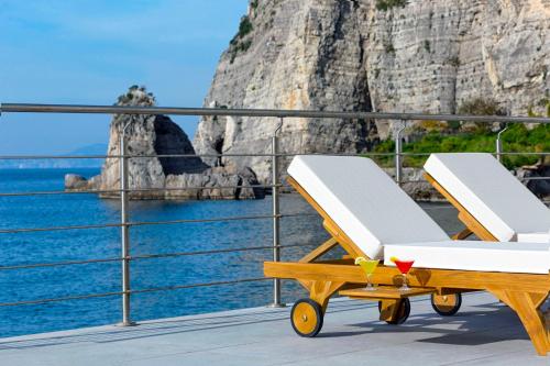 a deck with a beach chair and a view of the ocean at Alimuri Bay Resort in Meta