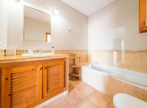 a bathroom with a sink and a tub and a mirror at Villa Can Petrus, con piscina y wifi gratis in San Antonio Bay