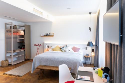 a bedroom with a white bed and a table at MOSAIC HOUSE Design Hotel in Prague